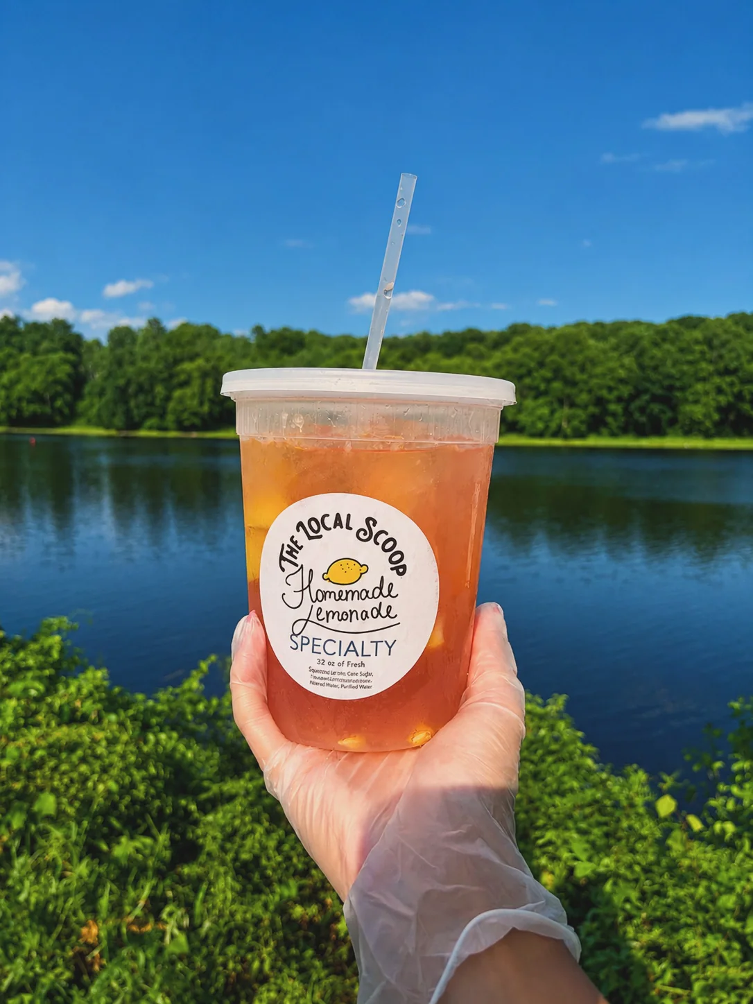 Fresh-squeezed lemonade held up in front of the river